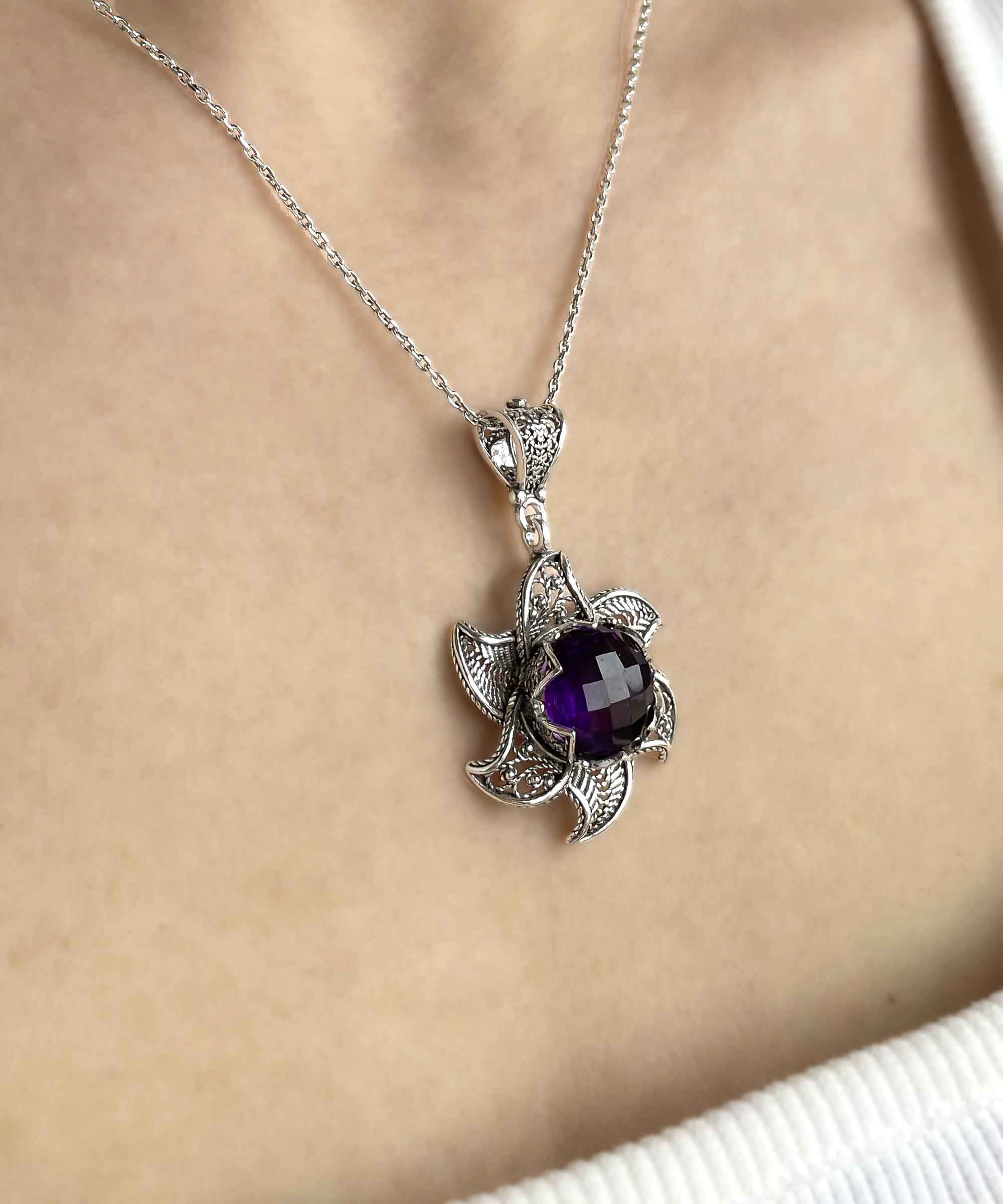 Sterling silver filigree lotus flower pendant with amethyst gemstone, elegantly designed and polished.