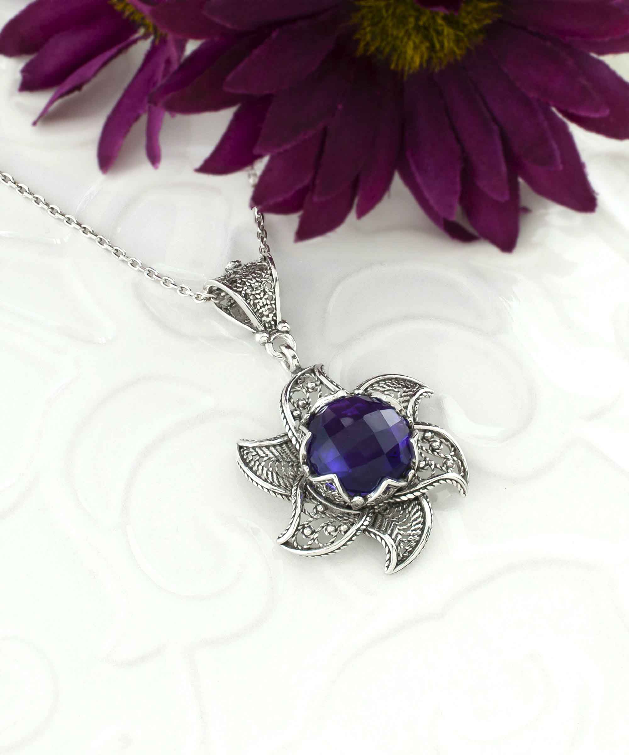 Sterling silver filigree lotus flower pendant with amethyst gemstone, elegantly designed and polished.