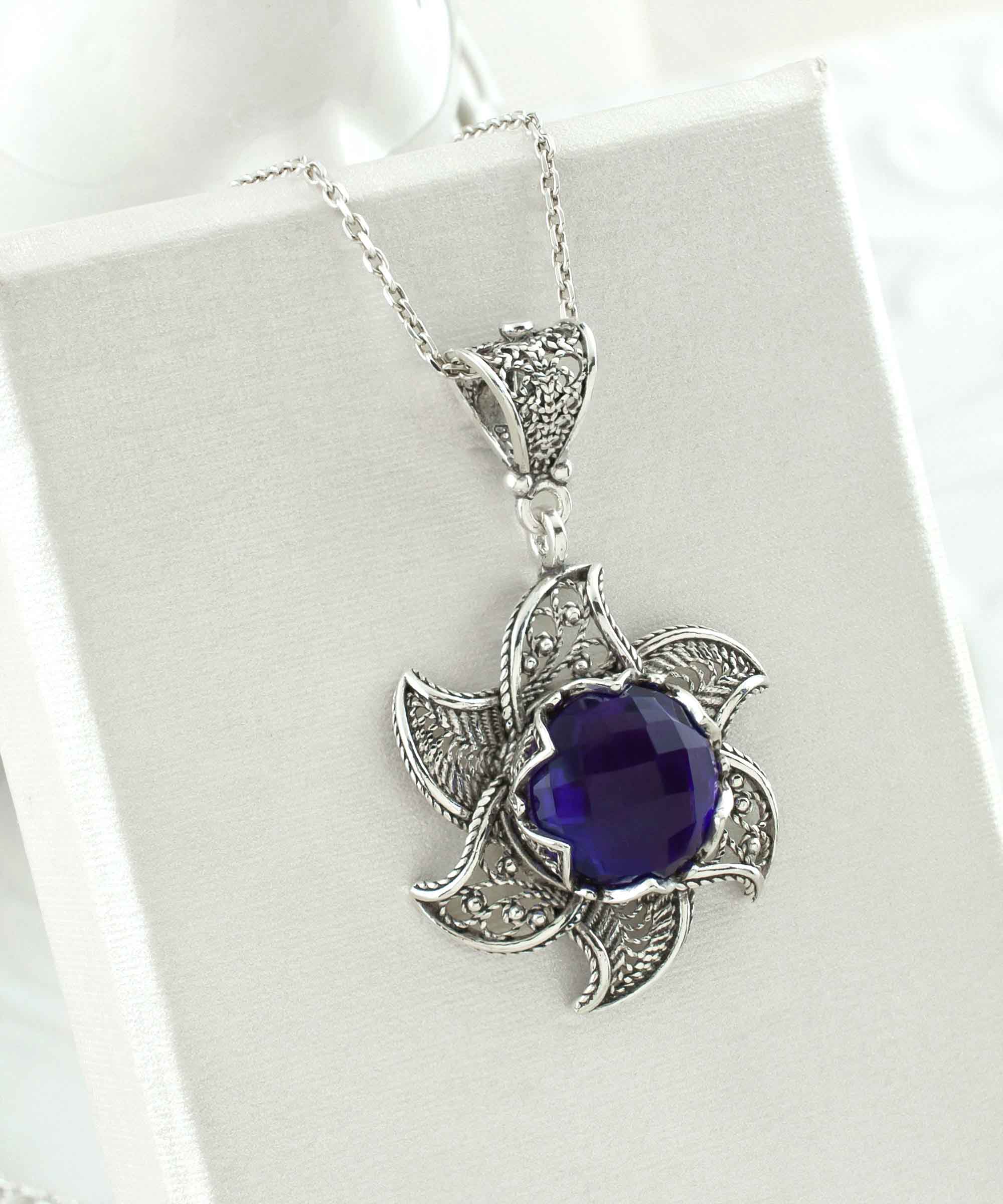 Sterling silver filigree lotus flower pendant with amethyst gemstone, elegantly designed and polished.