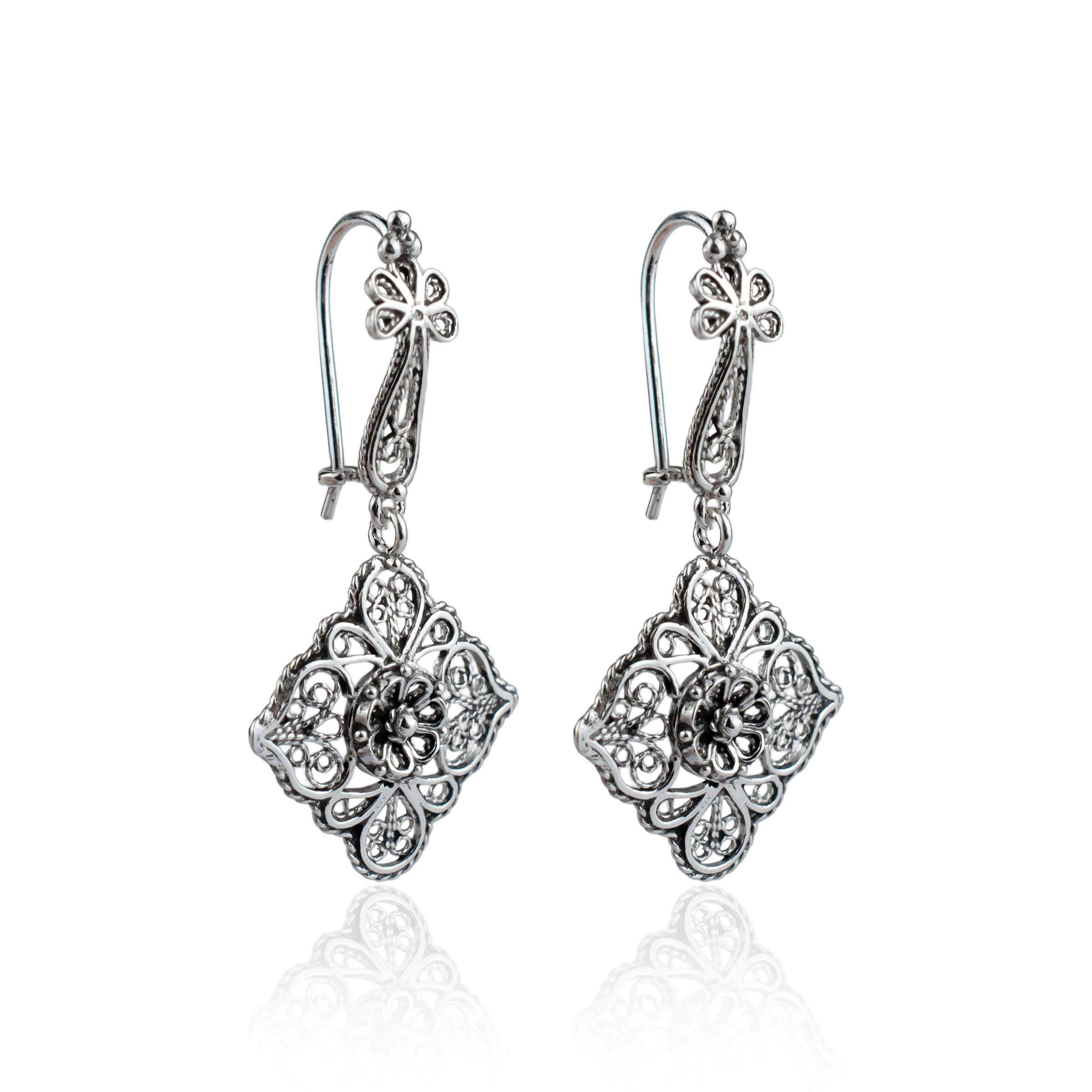 Elegant sterling silver dangle drop earrings featuring intricate filigree flower design, showcasing craftsmanship and sophistication.