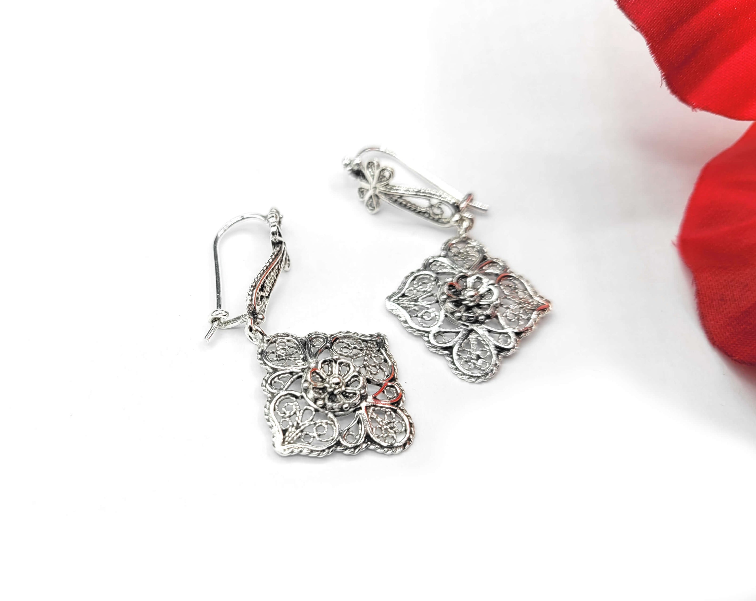 Elegant sterling silver dangle drop earrings featuring intricate filigree flower design, showcasing craftsmanship and sophistication.