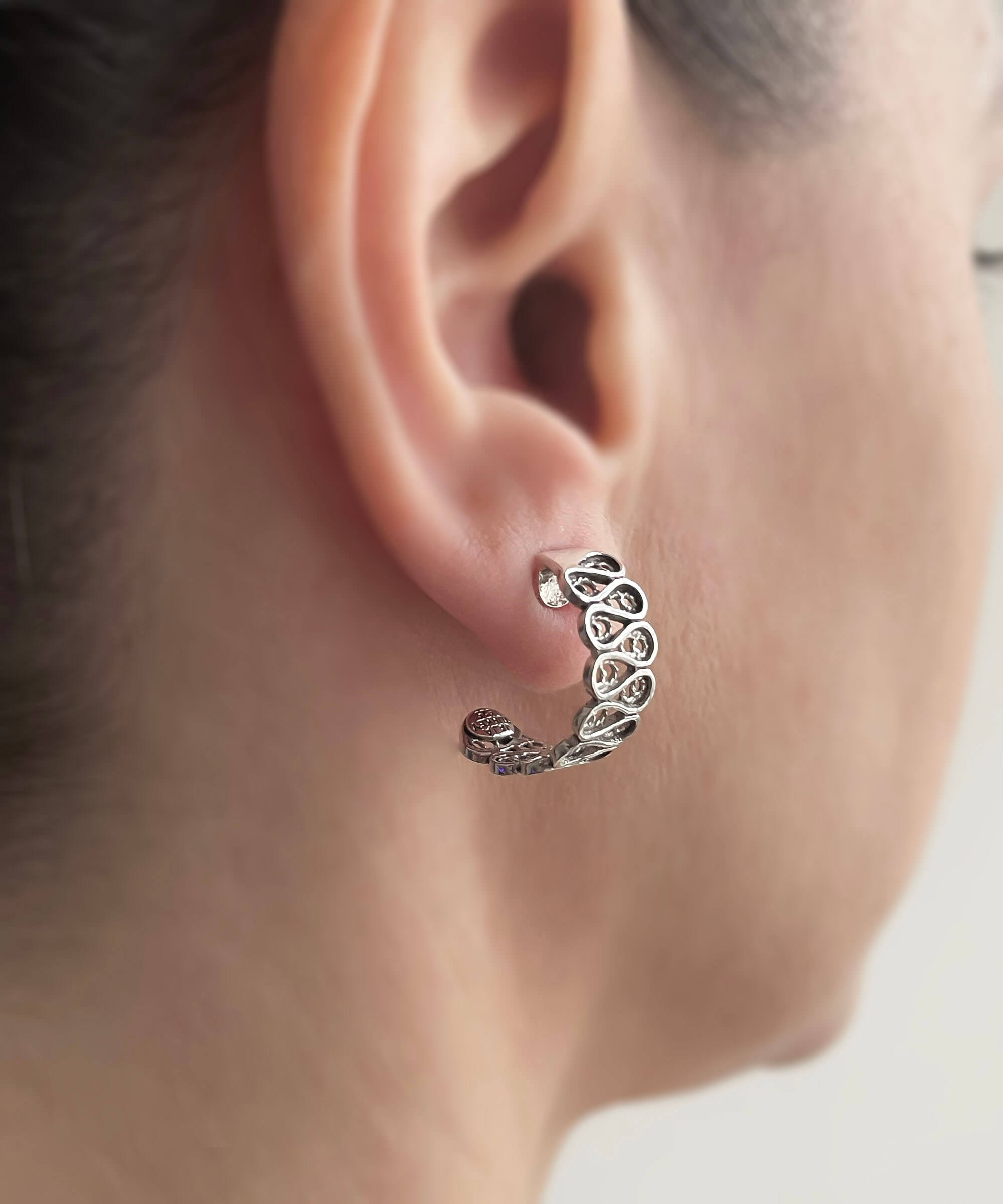 Elegant sterling silver filigree drop earrings with C hoop design, showcasing intricate detailing and polished finish.