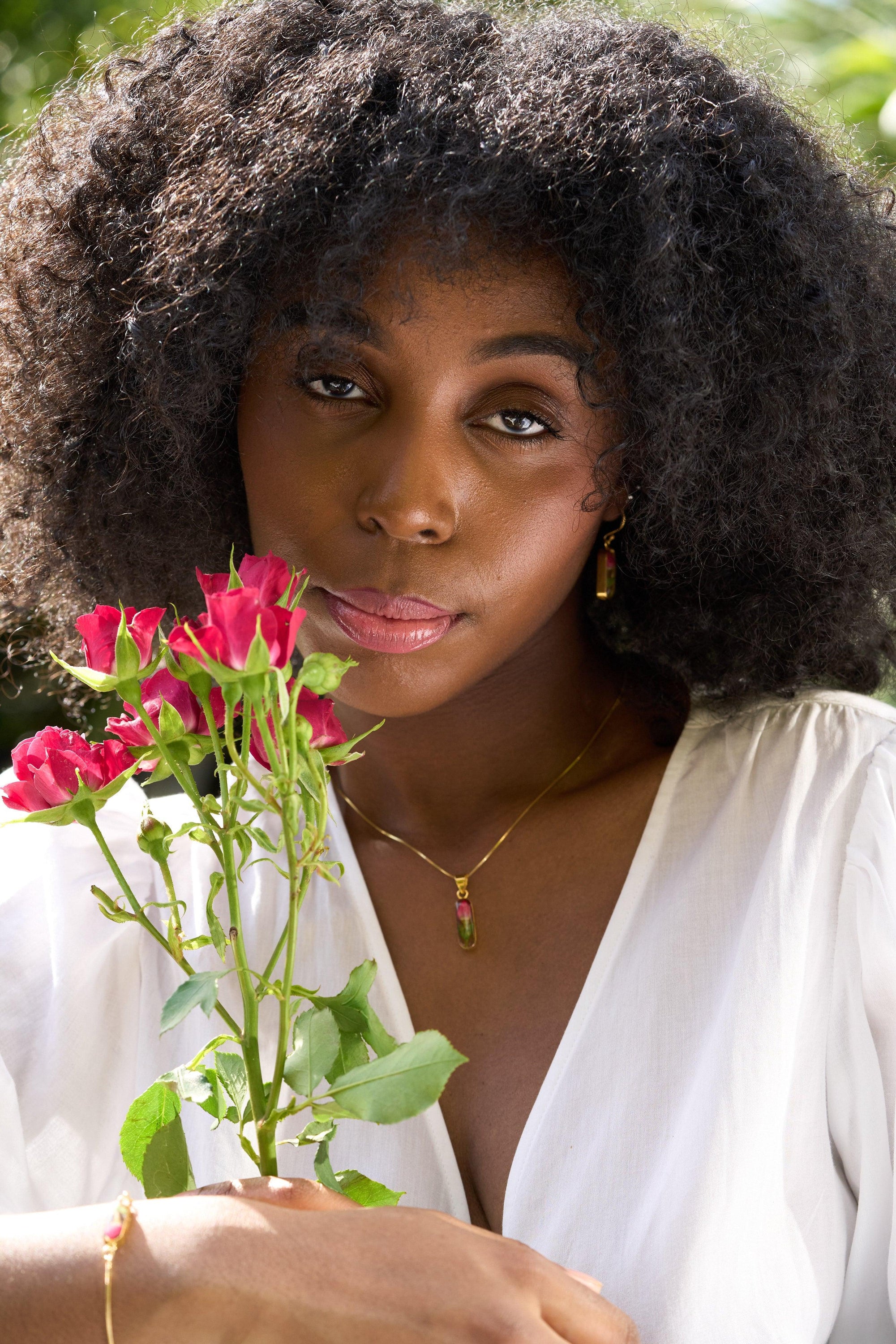 Sterling silver snake chain bracelet featuring a delicate rose bud charm, elegantly displayed in a gift box.