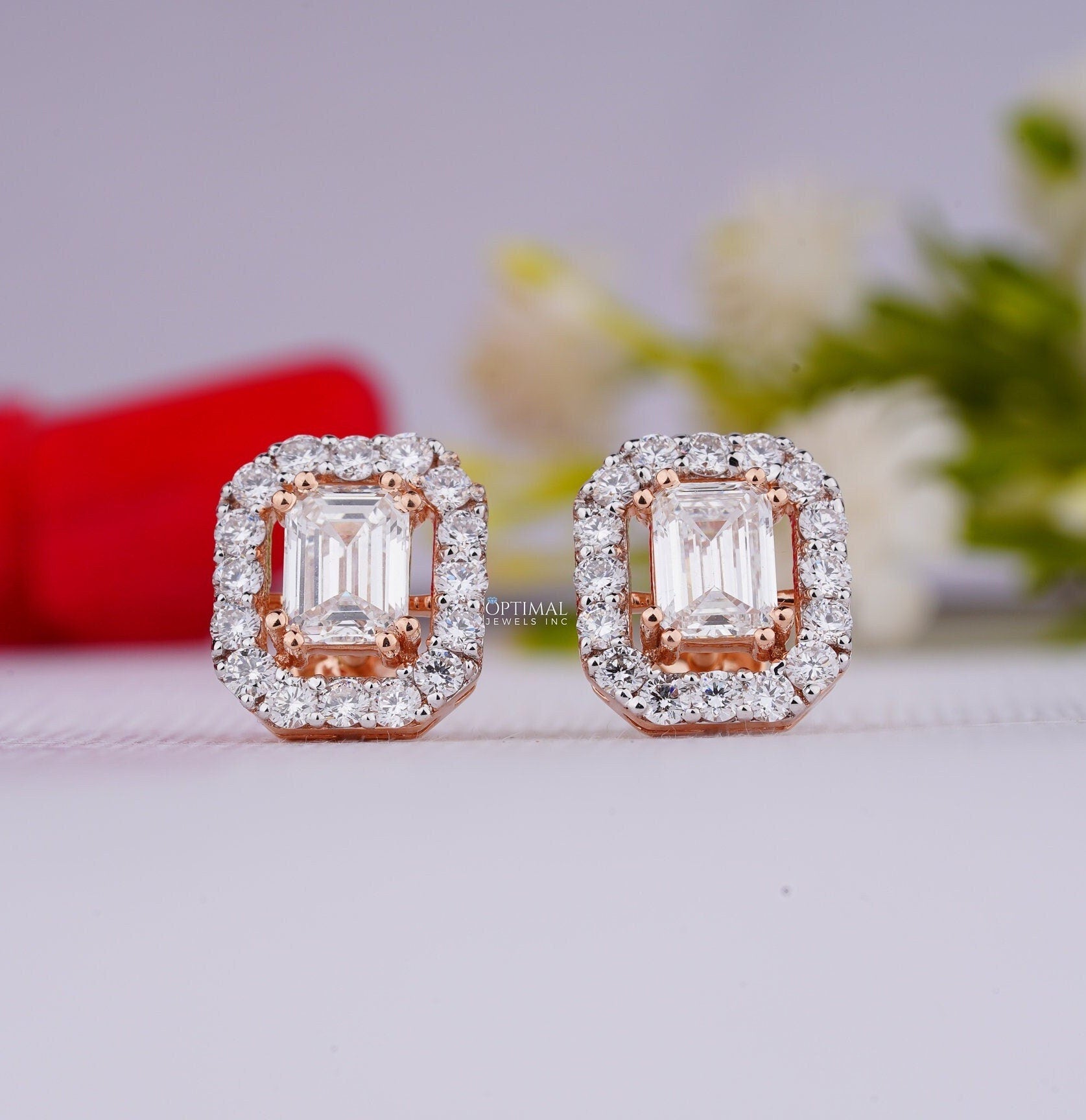 Stunning emerald lab grown diamond earrings featuring a central emerald cut diamond and round cut halo in rose gold setting.