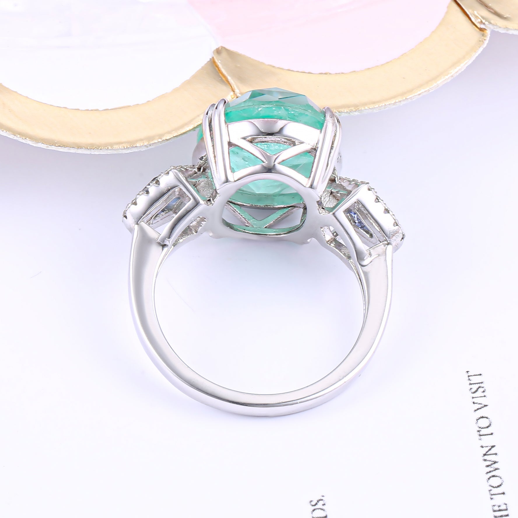 A stunning halo ring featuring tanzanite and tourmaline stones set in 925 sterling silver with a white gold finish, showcasing its vibrant colors and elegant design.