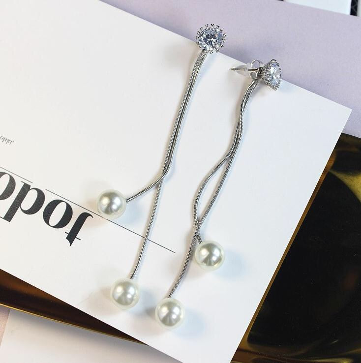 A pair of long tassel earrings featuring rhinestones and pearls, elegantly designed for a stylish look.