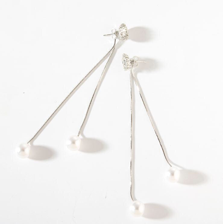 A pair of long tassel earrings featuring rhinestones and pearls, elegantly designed for a stylish look.