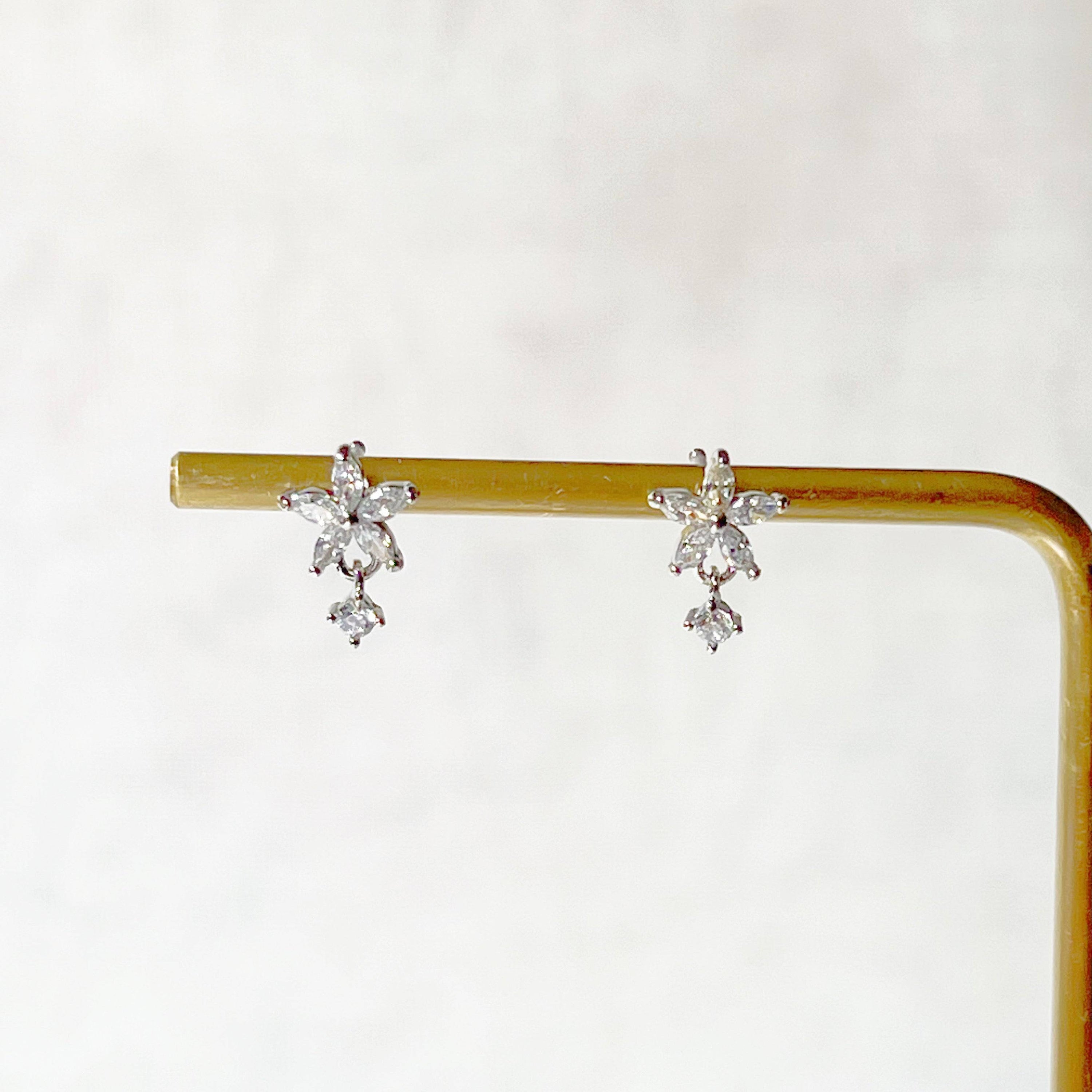 A pair of delicate surgical steel flower earrings featuring clear zircon crystals, elegantly designed for sensitive ears.