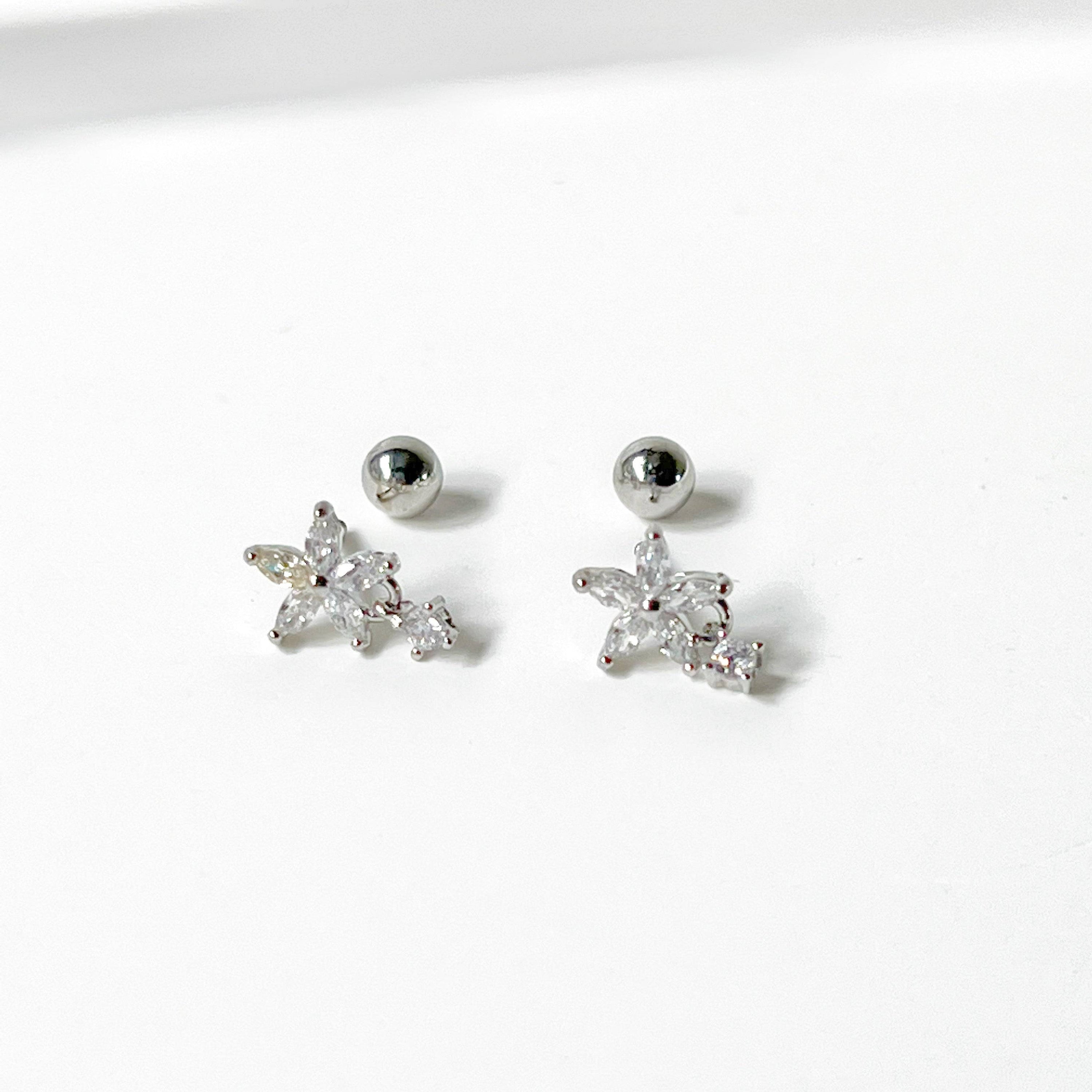 A pair of delicate surgical steel flower earrings featuring clear zircon crystals, elegantly designed for sensitive ears.