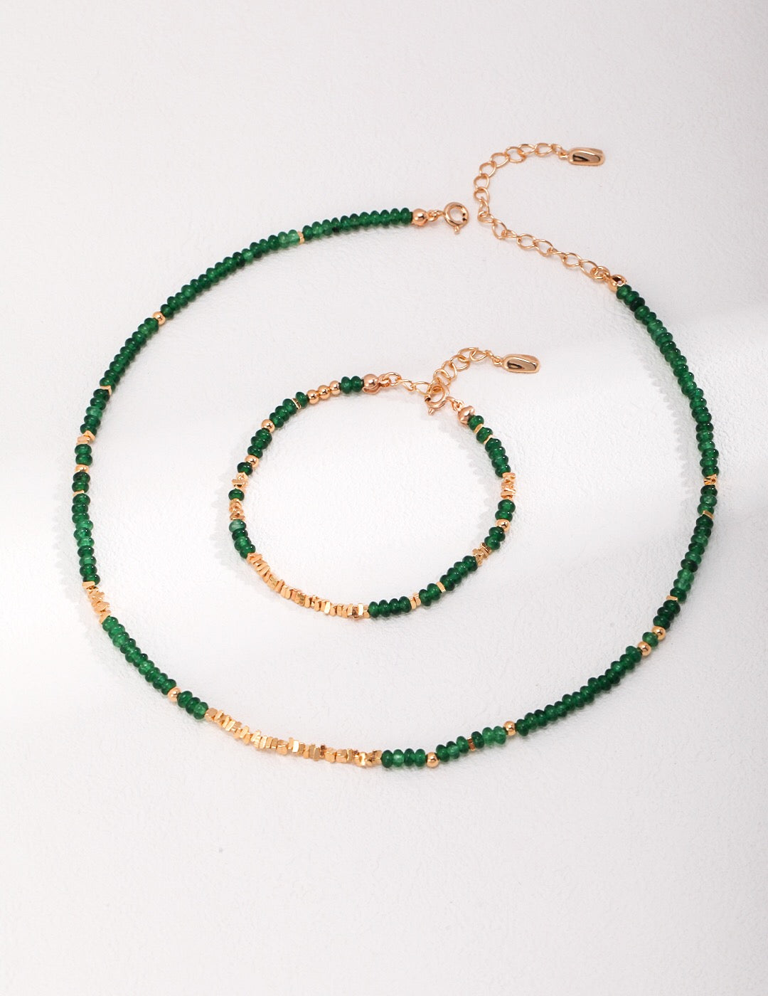 A stunning handmade synthetic emerald beaded necklace with gold vermeil accents, elegantly displayed on a soft background.