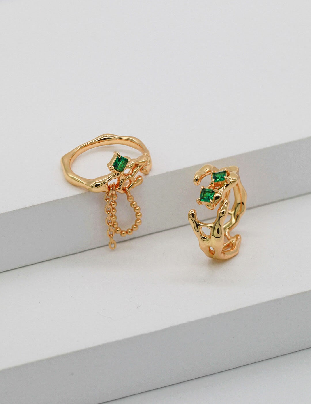 A stunning synthetic green spinel open ring, featuring gold vermeil plating and an adjustable design, elegantly displayed on a soft fabric background.