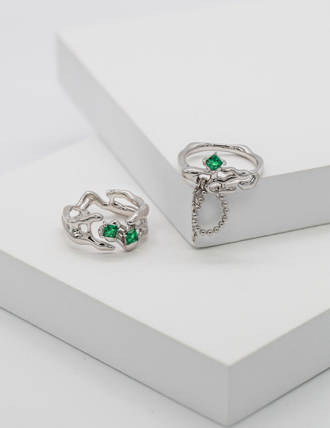 A stunning synthetic green spinel open ring, featuring gold vermeil plating and an adjustable design, elegantly displayed on a soft fabric background.