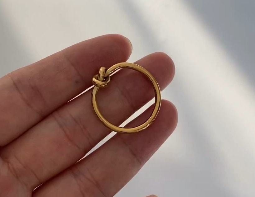 Syrakus Simple Gold Knot Ring showcasing a sleek design with a gold finish, symbolizing unity and connection.