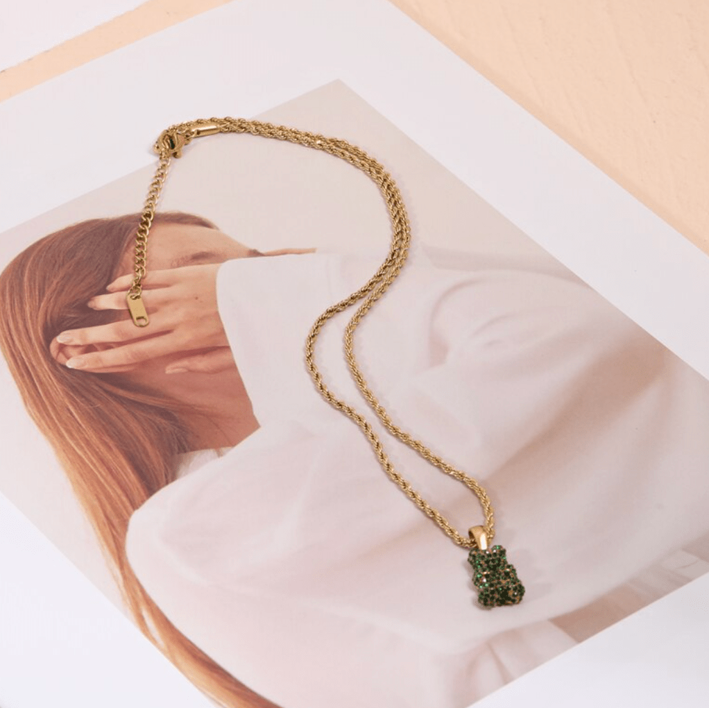 Tam Encrusted Teddy Bear Sparkle Charm Necklace featuring a teddy bear charm with sparkling crystals on a gold rope chain.