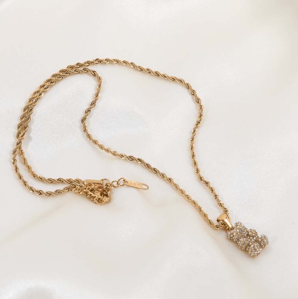 Tam Encrusted Teddy Bear Sparkle Charm Necklace featuring a teddy bear charm with sparkling crystals on a gold rope chain.
