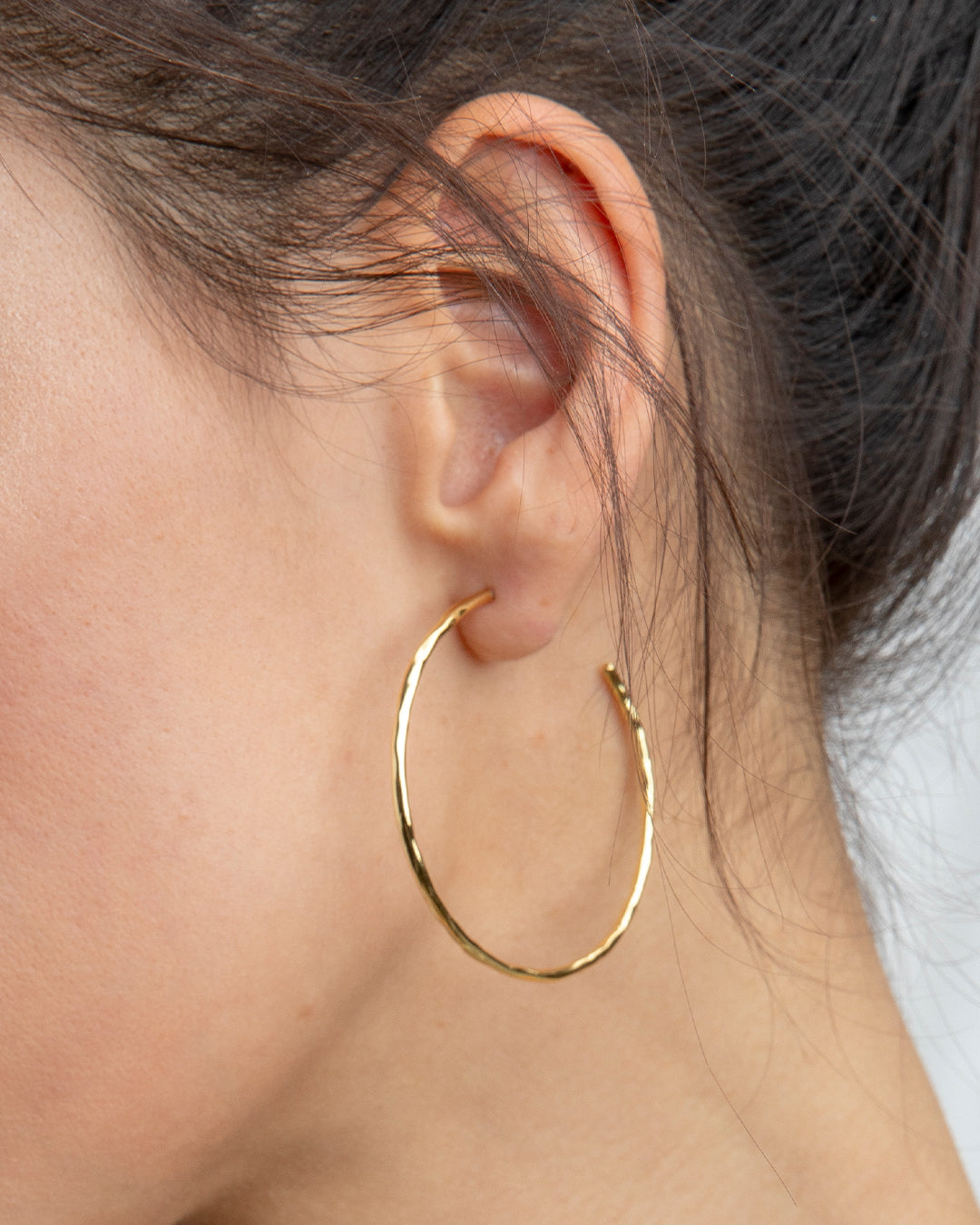A pair of Taner Hoops showcasing their sleek and sophisticated design, handcrafted with high-quality materials.