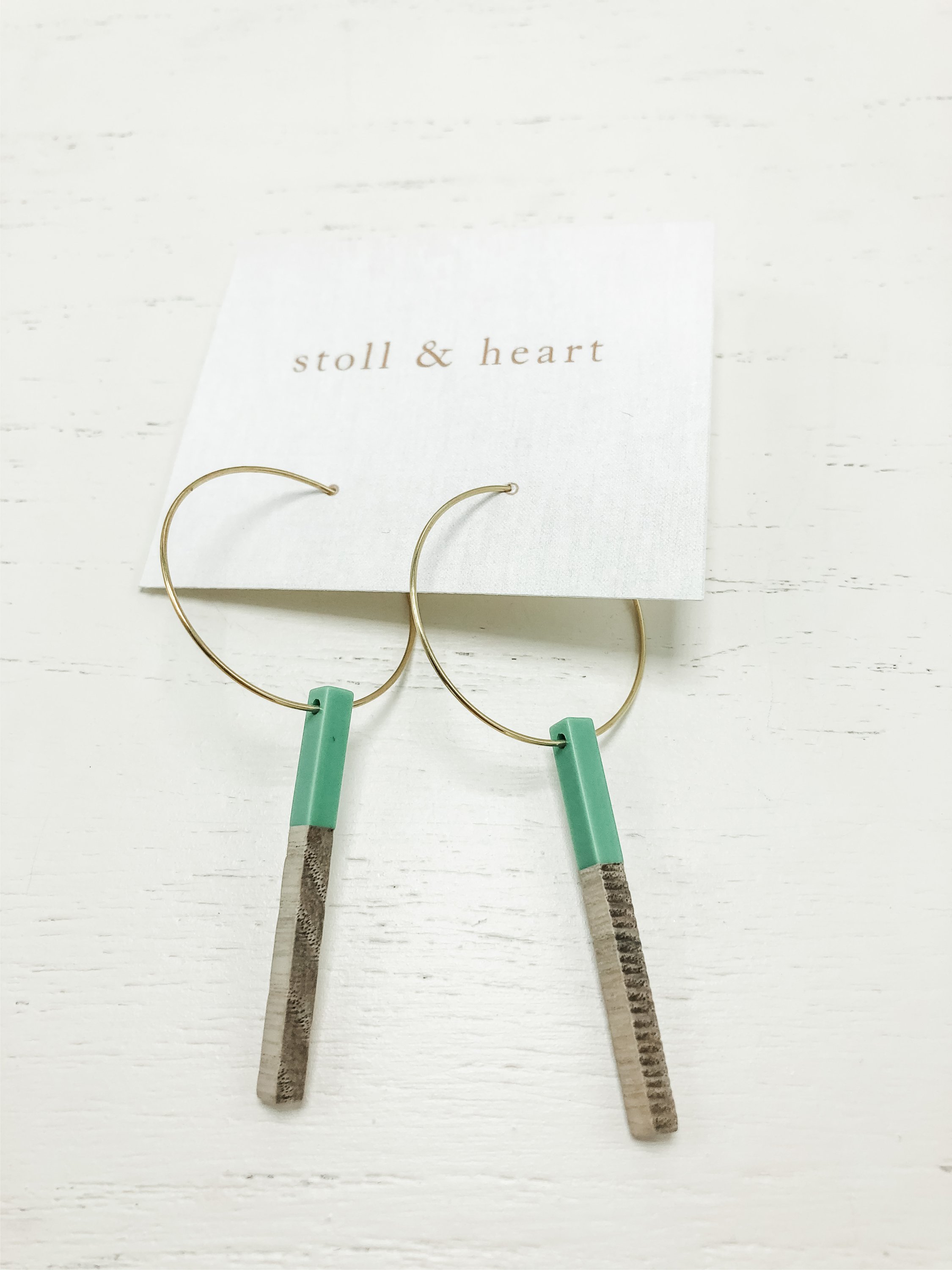 Gold plated hoop earrings featuring wood and green resin details, elegantly designed by Stoll & Heart.