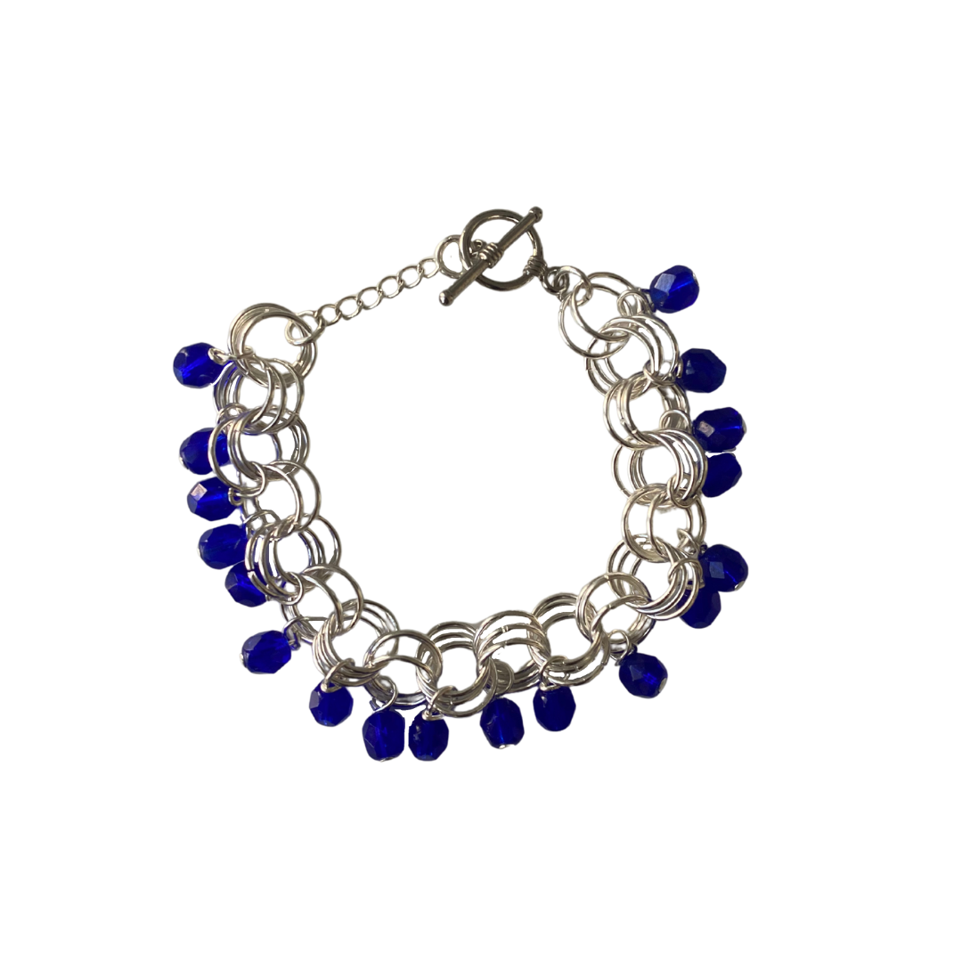 The Donna Bracelet in Cobalt Blue featuring Czech glass beads and a toggle clasp, elegantly displayed on a soft surface.