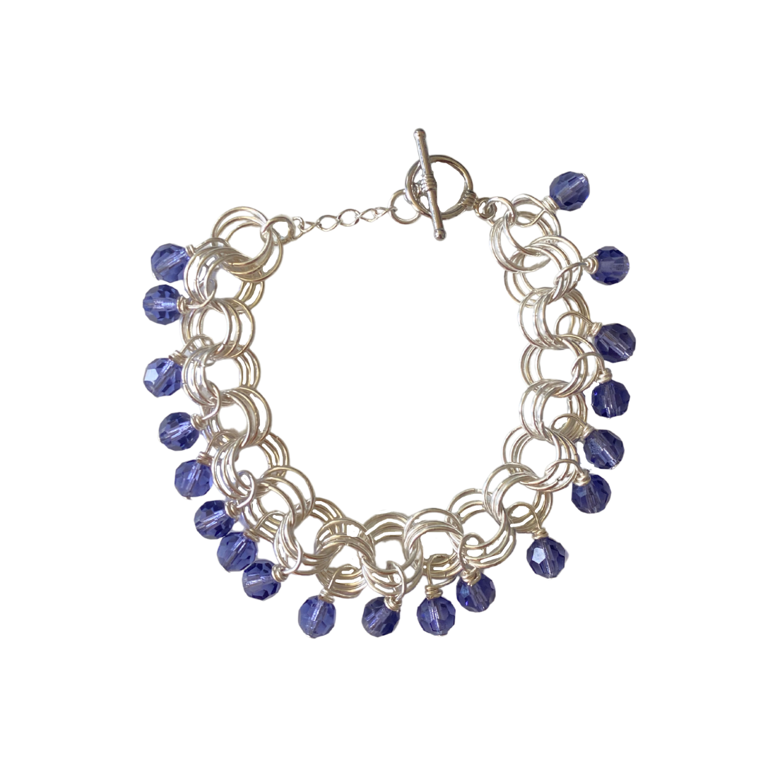The Donna Bracelet in Tanzanite featuring gold/silver-plated links and tanzanite Czech fire-polished glass beads with a toggle clasp.