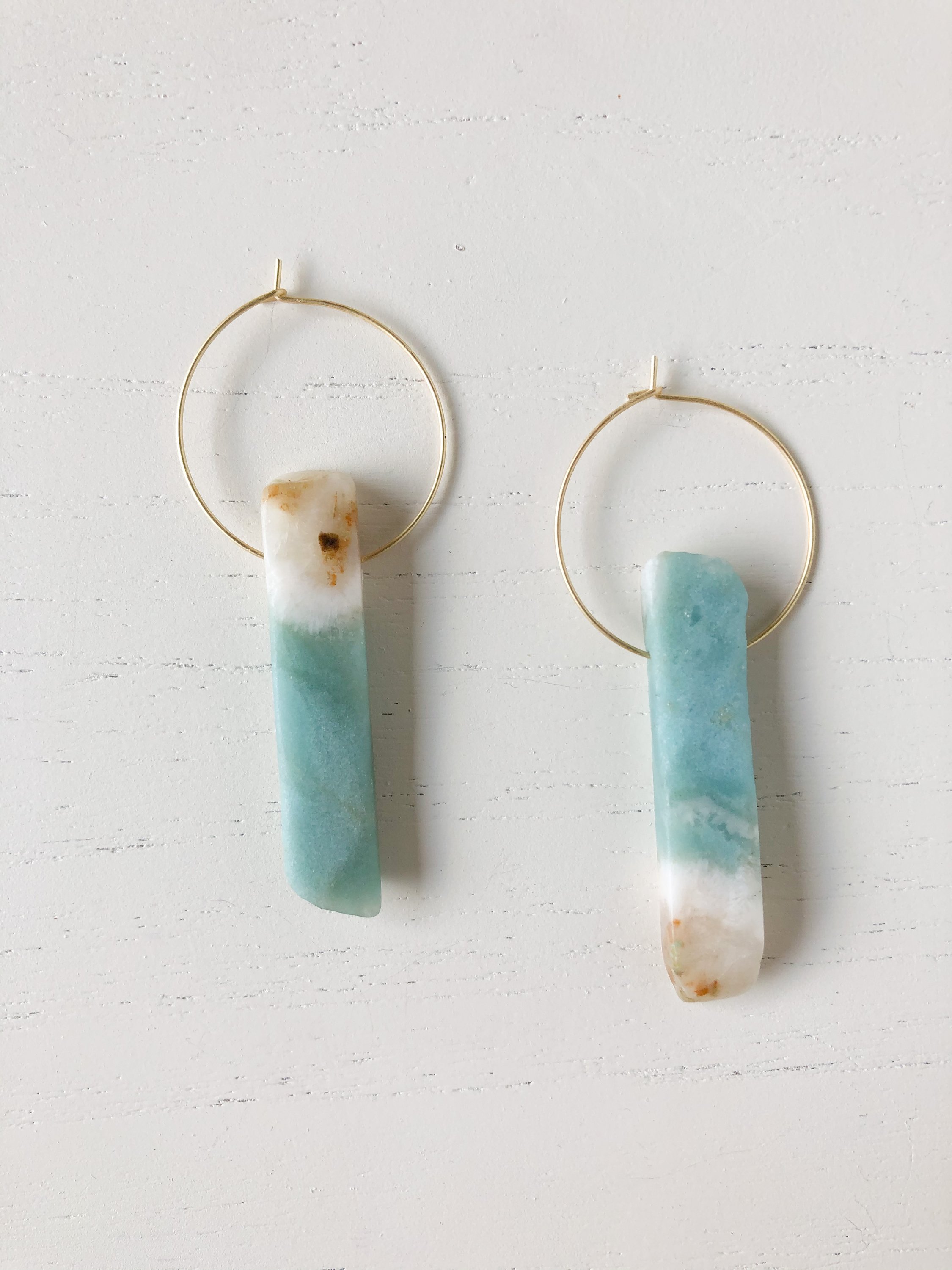 A pair of unique Henley Amazonite earrings featuring brass hoops and natural amazonite stones, showcasing their elegant design.