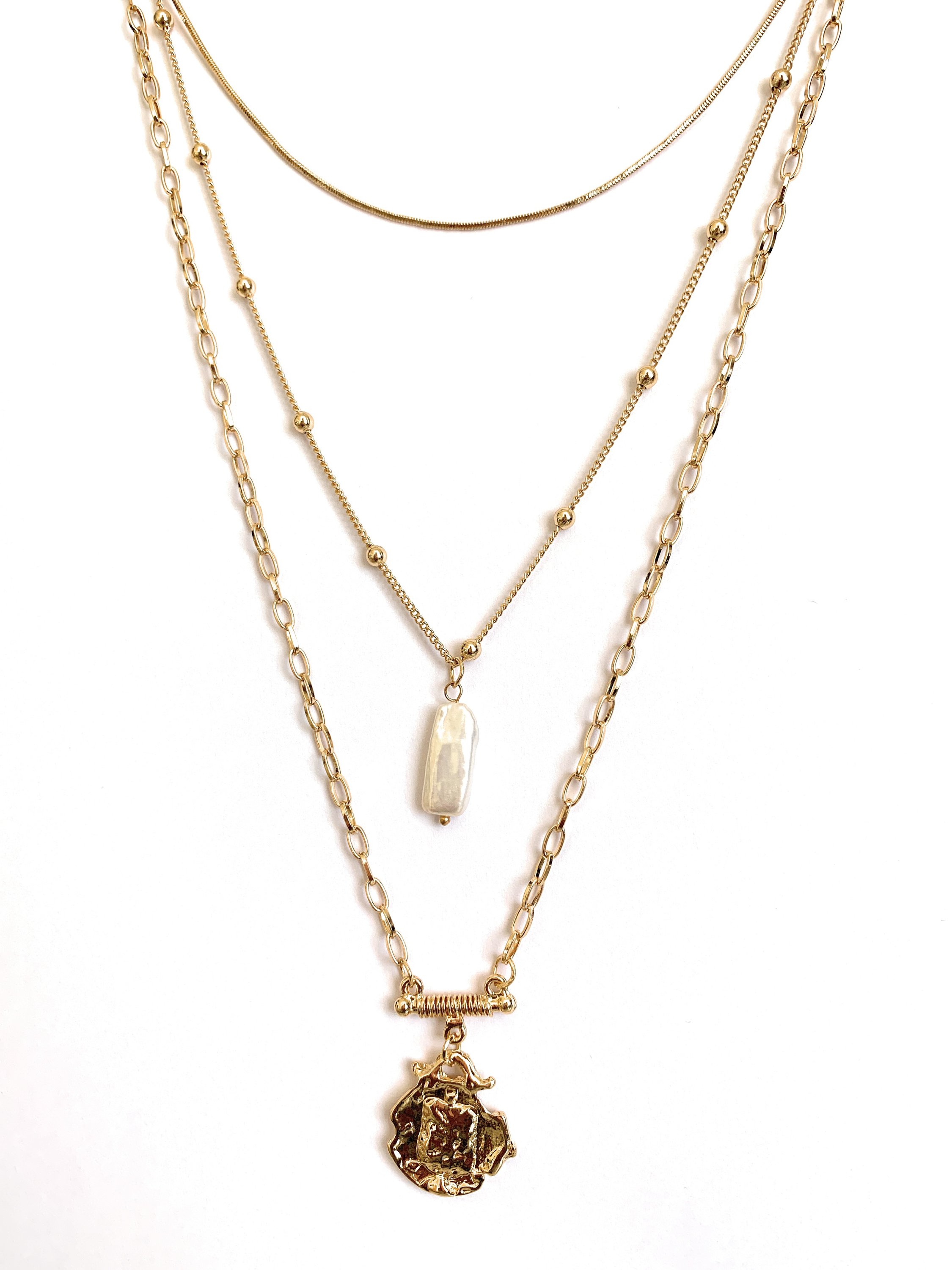 Three layer necklace featuring simulated pearl and gold pendant, elegantly designed with textured links and beaded accents.