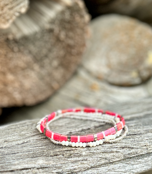 A vibrant magenta-pink and white stretchy Tila bead bracelet, showcasing unique handmade craftsmanship with Miyuki Tila beads.
