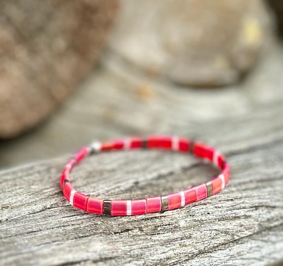A vibrant magenta-pink and white stretchy Tila bead bracelet, showcasing unique handmade craftsmanship with Miyuki Tila beads.