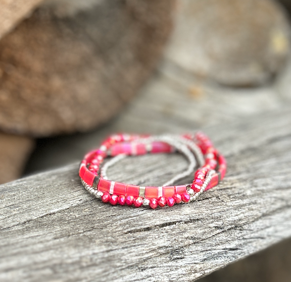 A vibrant magenta-pink and white stretchy Tila bead bracelet, showcasing unique handmade craftsmanship with Miyuki Tila beads.