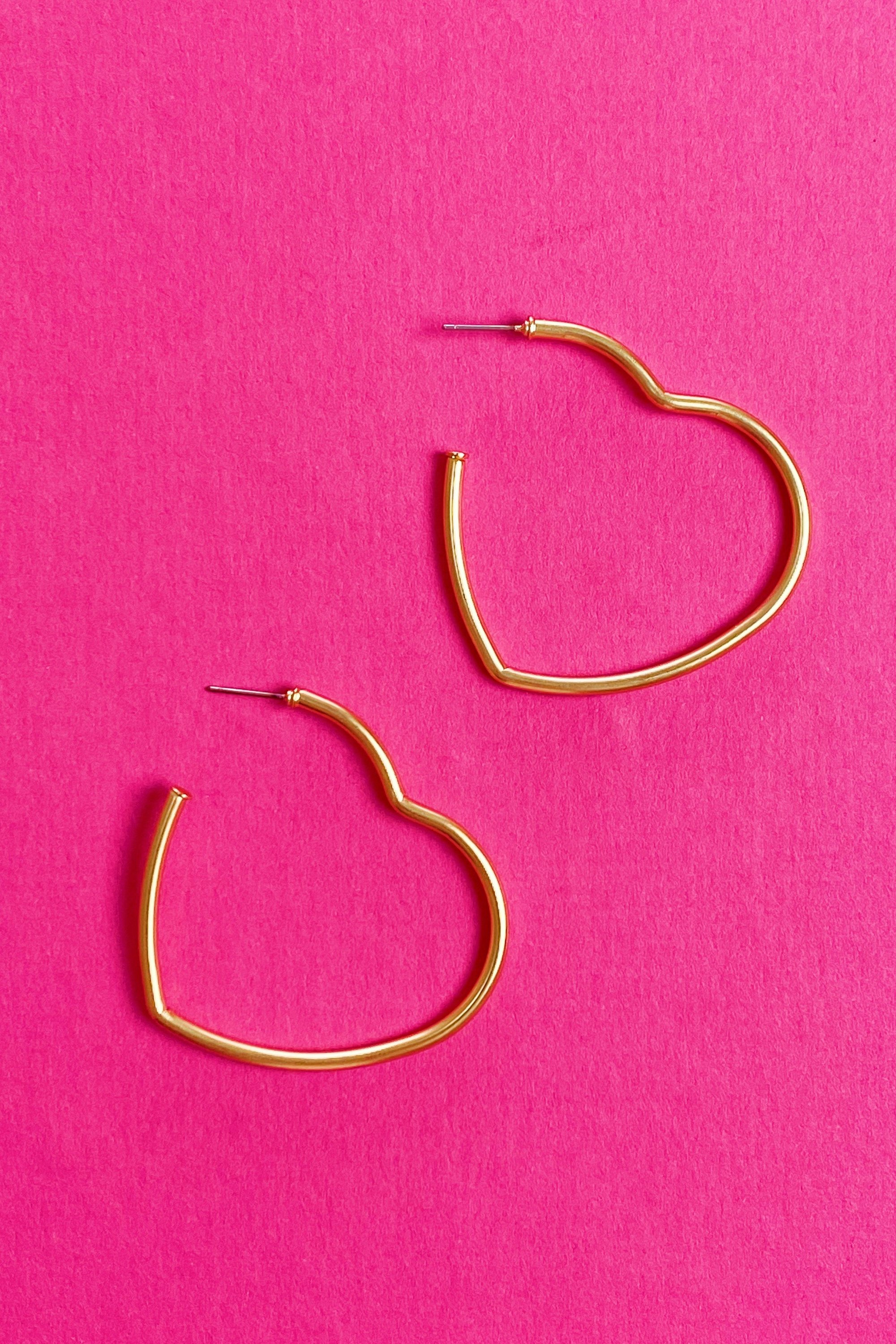 Timeless Hearts Earrings in gold featuring open heart hoop design with a matte finish, elegantly displayed against a soft background.