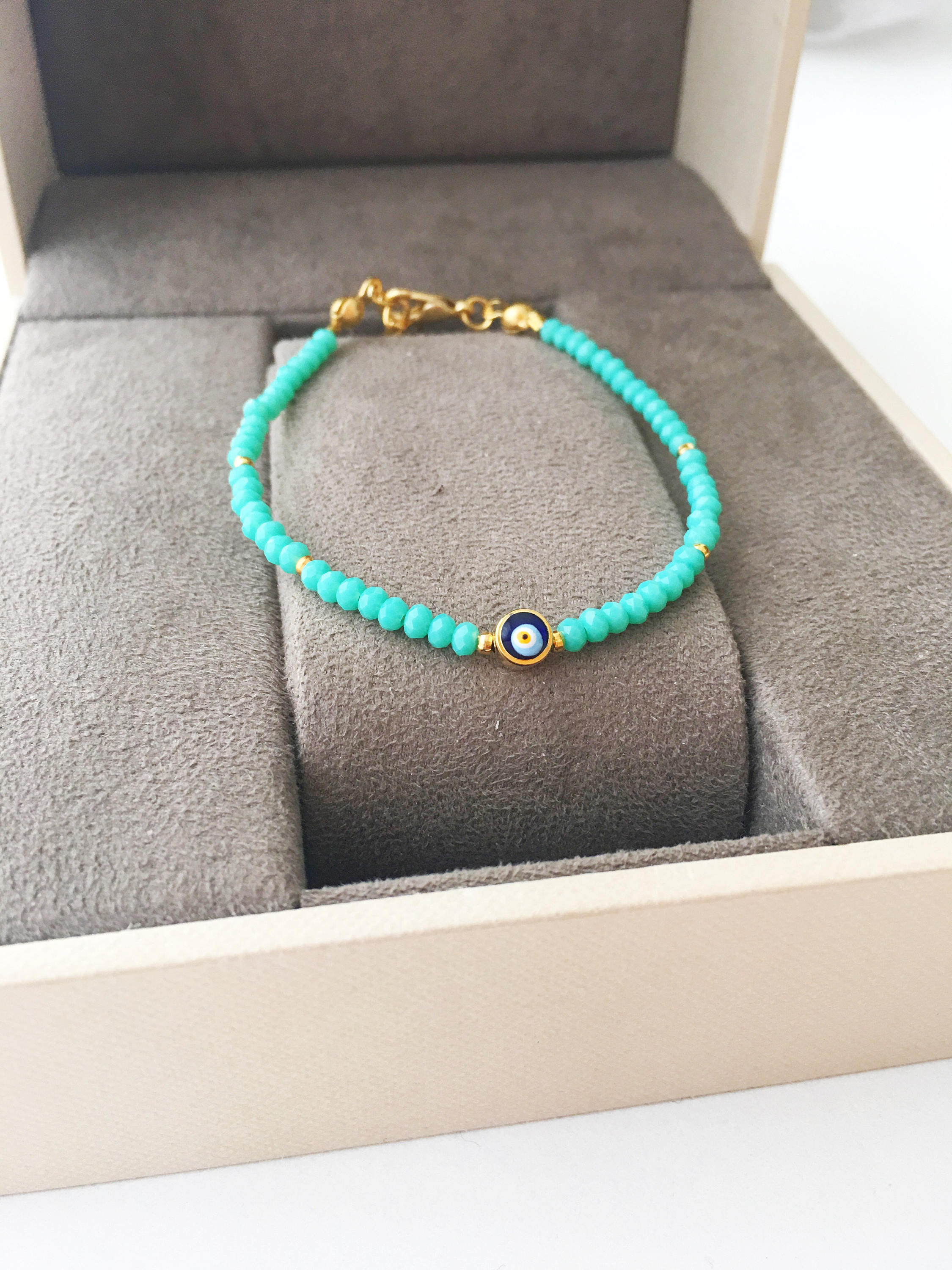 A colorful Tiny Evil Eye Bracelet made with Miyuki seed beads featuring a protective evil eye charm, showcasing vibrant colors.