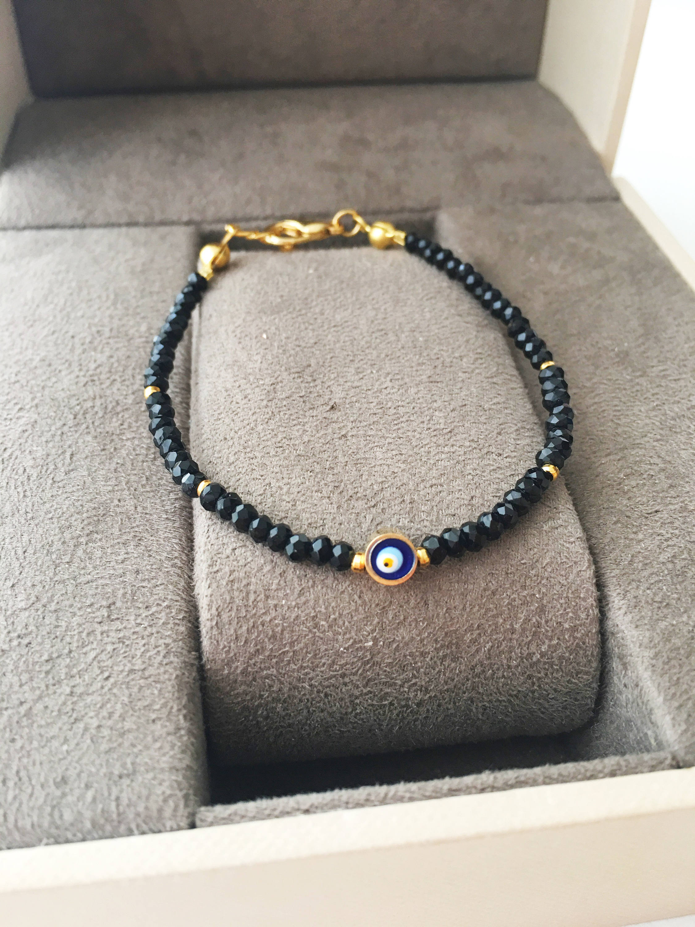 A colorful Tiny Evil Eye Bracelet made with Miyuki seed beads featuring a protective evil eye charm, showcasing vibrant colors.