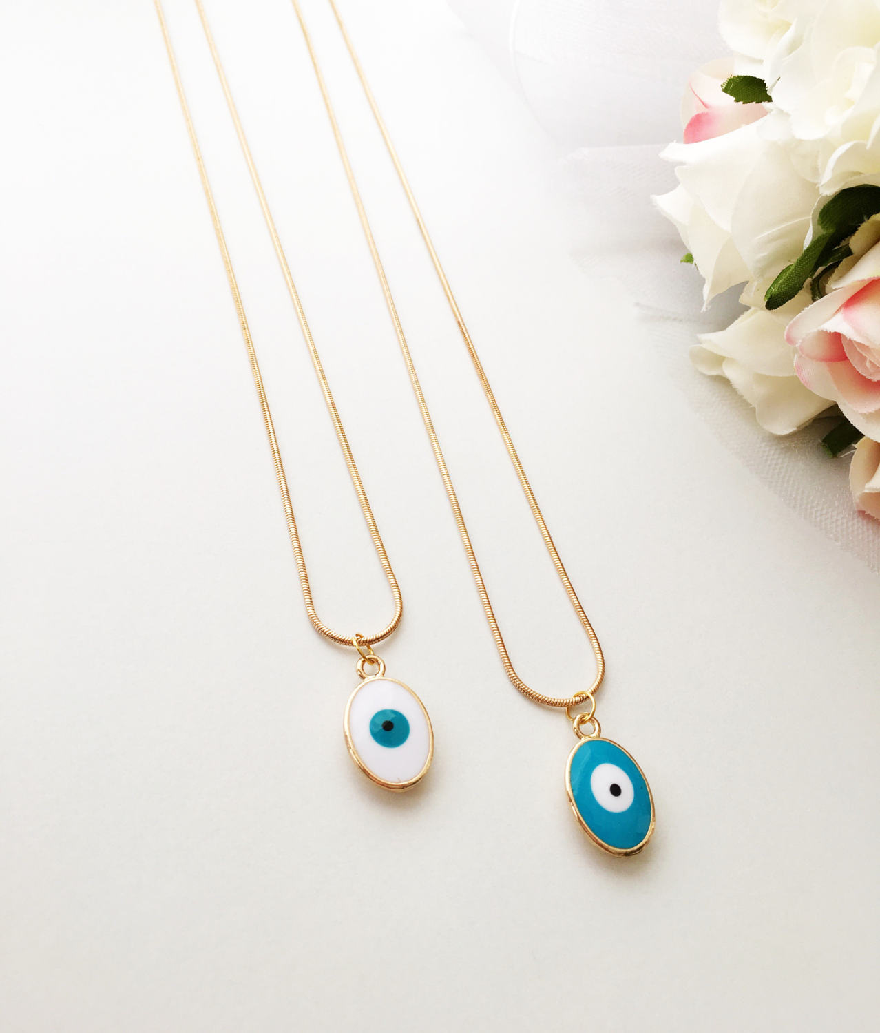 A delicate Tiny Evil Eye Necklace featuring turquoise and white oval beads on a 22K gold plated chain, symbolizing protection and style.