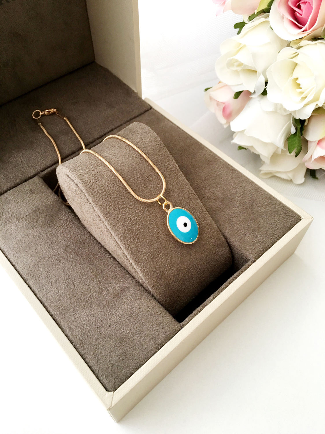 A delicate Tiny Evil Eye Necklace featuring turquoise and white oval beads on a 22K gold plated chain, symbolizing protection and style.