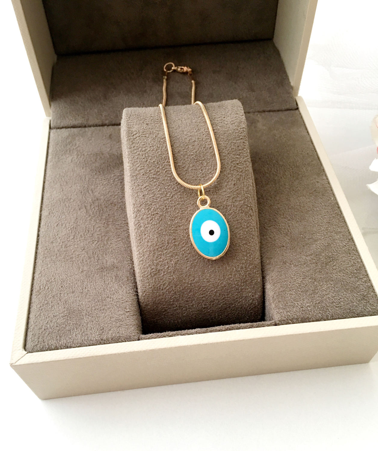 A delicate Tiny Evil Eye Necklace featuring turquoise and white oval beads on a 22K gold plated chain, symbolizing protection and style.