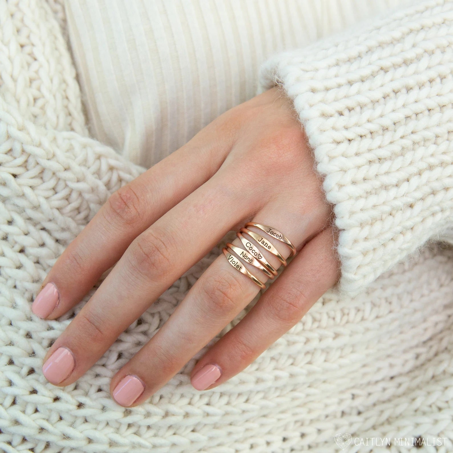 A delicate Tiny Name Ring in gold, silver, and rose gold finishes, showcasing personalized names in elegant fonts.