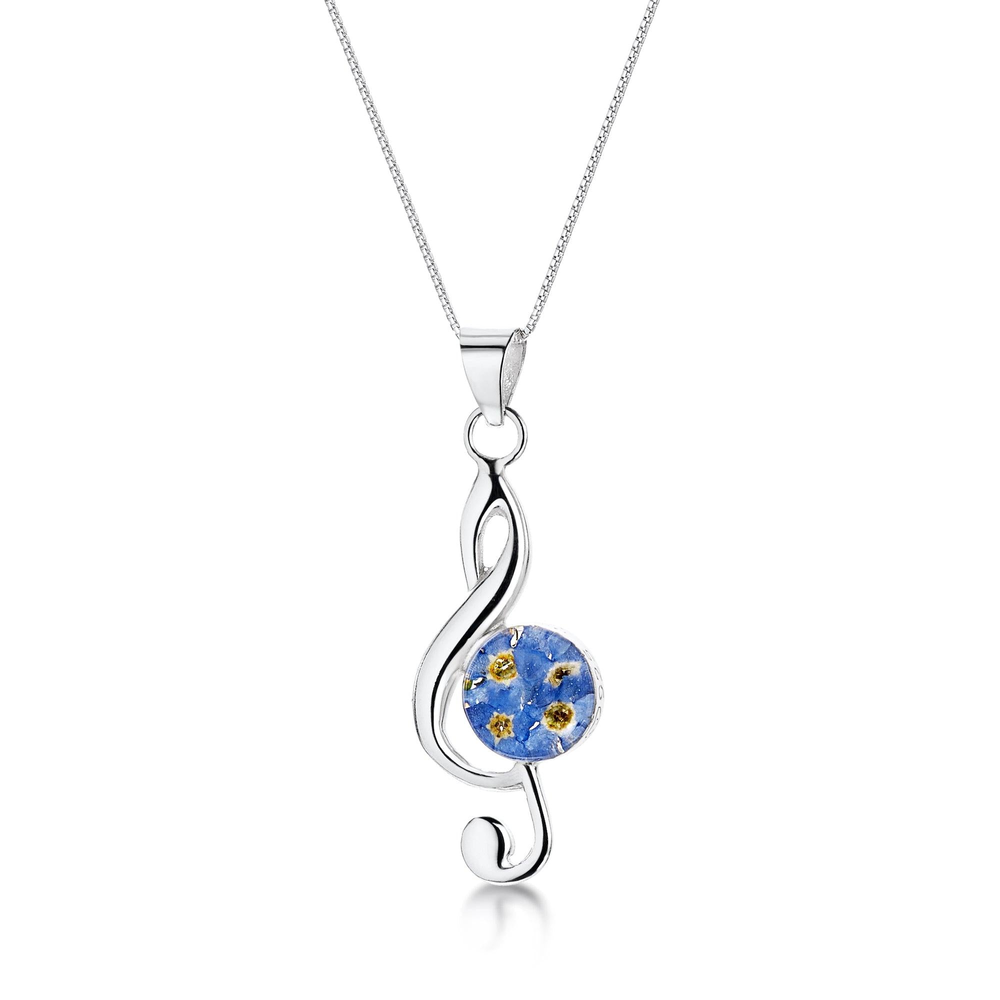 Treble clef musical note necklace featuring real forget-me-not flowers encased in resin, with a sterling silver chain.