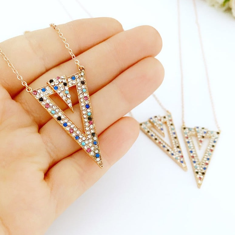 A beautiful triangle necklace featuring a rainbow zircon charm on a delicate rose gold chain, showcasing its geometric design.