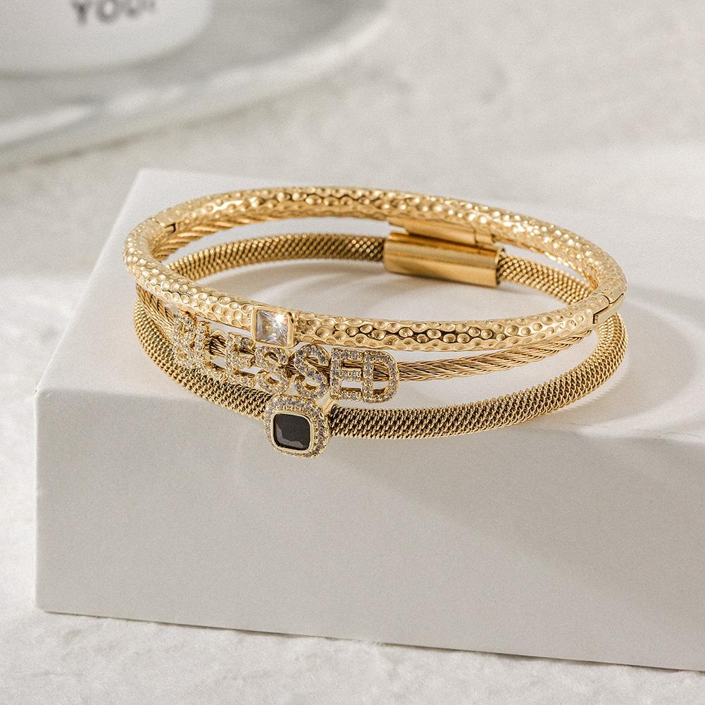 Triple Bangle Set featuring 'blessed' design in gold with cubic zirconia accents, elegantly displayed in a gift box.