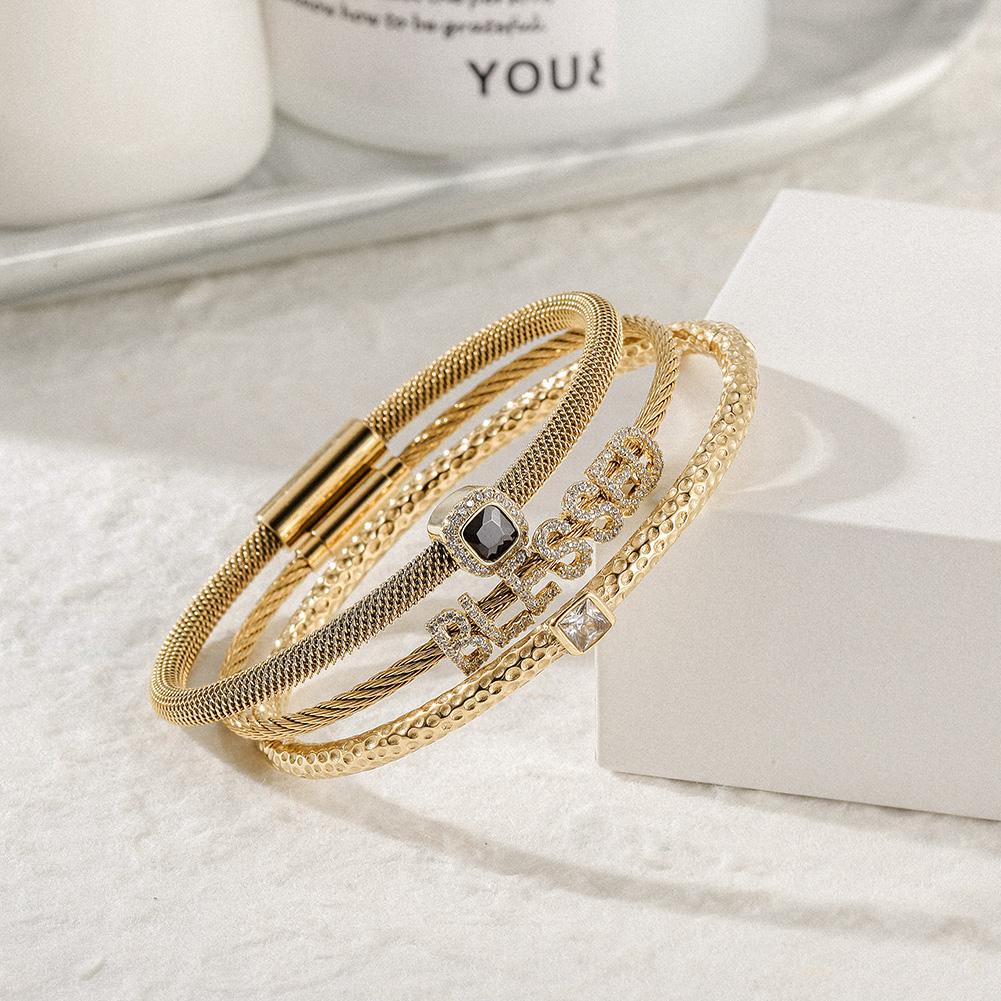Triple Bangle Set featuring 'blessed' design in gold with cubic zirconia accents, elegantly displayed in a gift box.