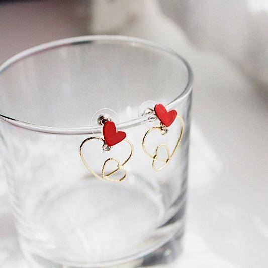 Triple Hearts Earrings featuring red and gold heart studs, symbolizing love and affection, elegantly designed for gifting or personal wear.