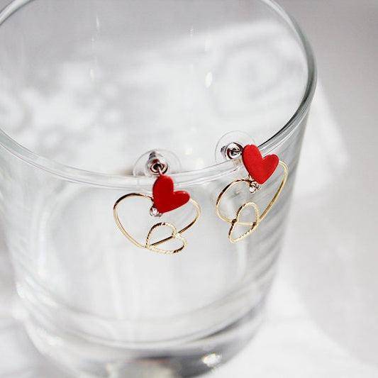Triple Hearts Earrings featuring red and gold heart studs, symbolizing love and affection, elegantly designed for gifting or personal wear.