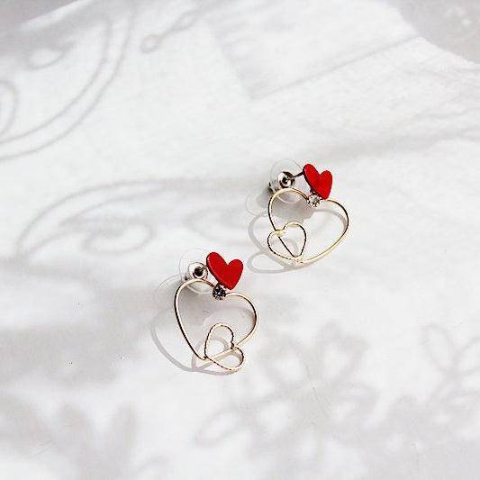 Triple Hearts Earrings featuring red and gold heart studs, symbolizing love and affection, elegantly designed for gifting or personal wear.