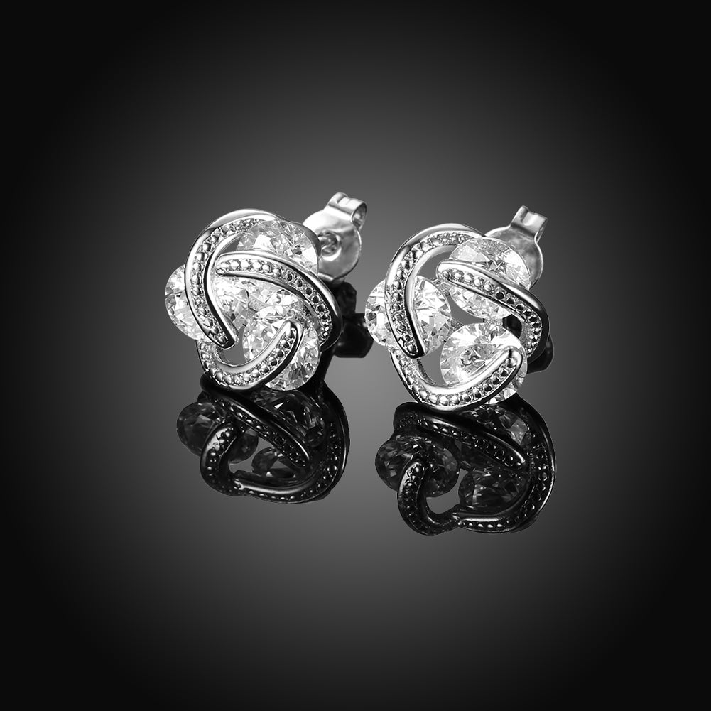 Triple Stone Knot Stud Earrings in 18K White Gold Plated with Crystals, featuring a unique design and sparkling stones.