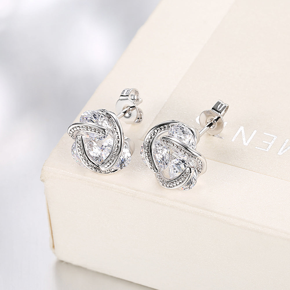 Triple Stone Knot Stud Earrings in 18K White Gold Plated with Crystals, featuring a unique design and sparkling stones.