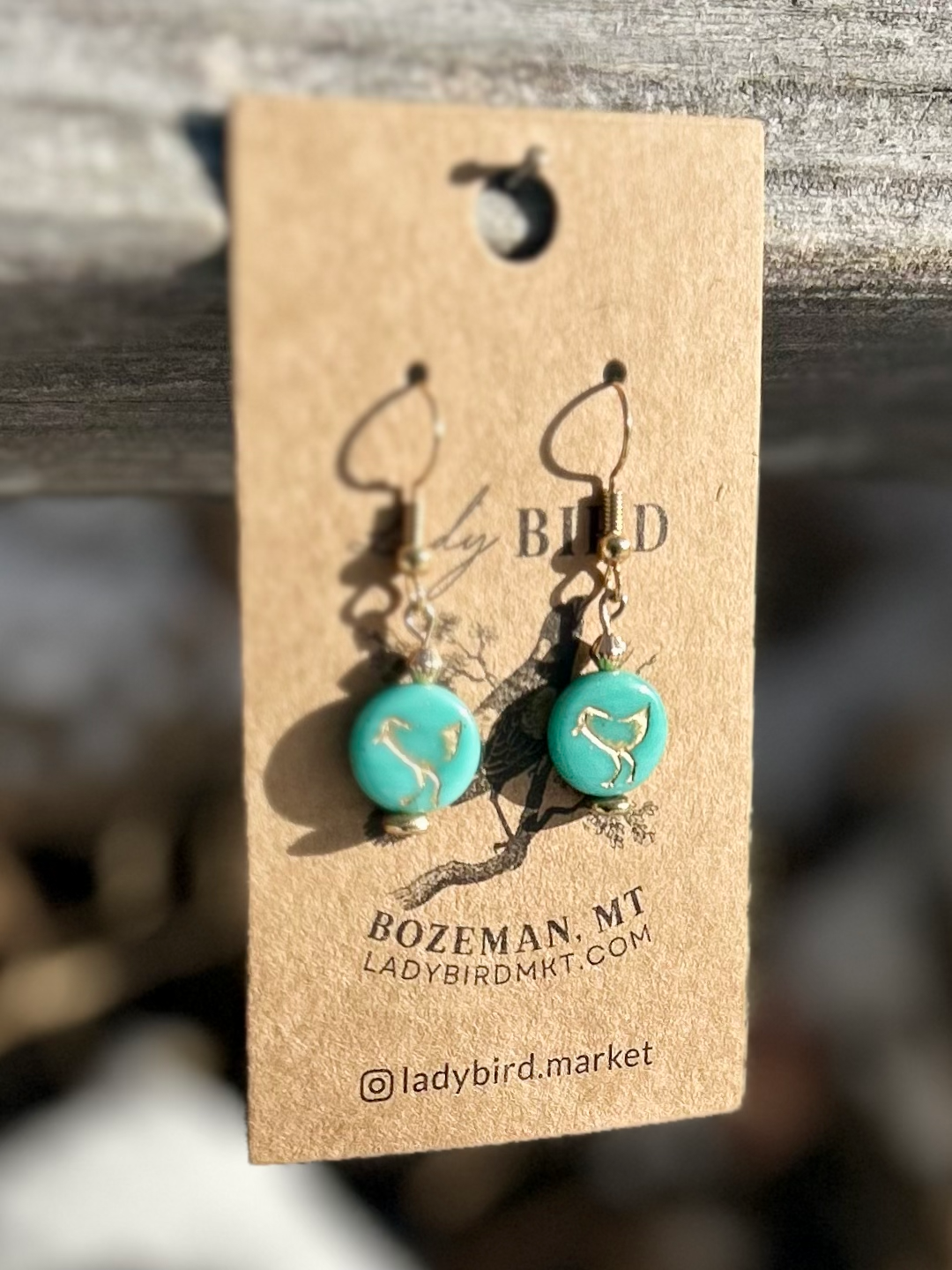Turquoise blue and gold etched glass earrings featuring a bird motif, showcasing Czech glass coin beads.
