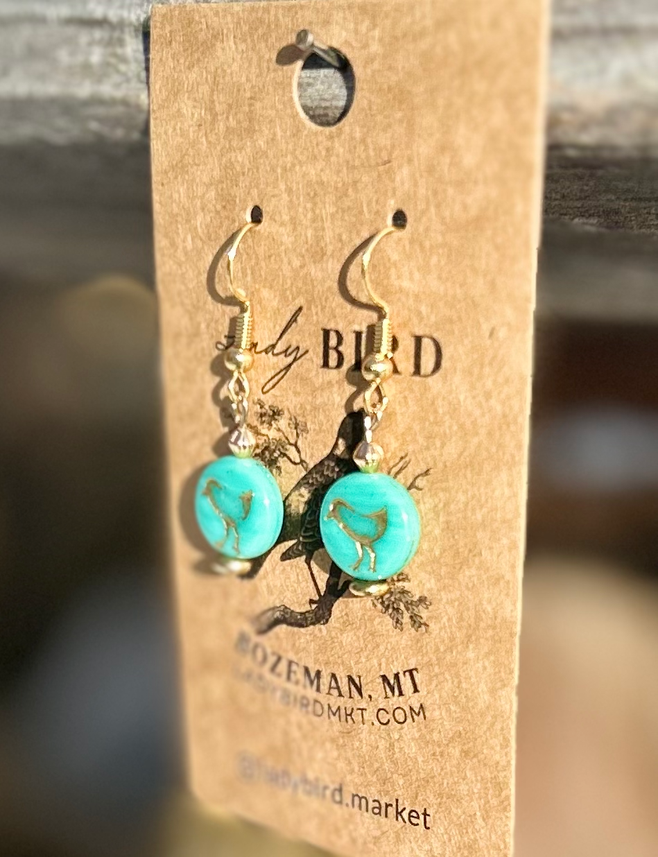 Turquoise blue and gold etched glass earrings featuring a bird motif, showcasing Czech glass coin beads.