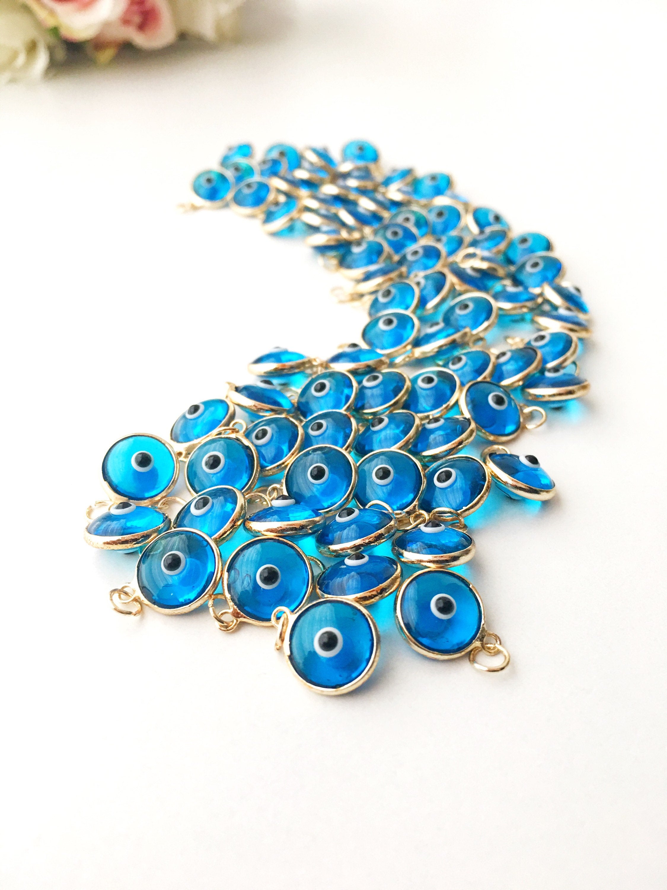 Turquoise evil eye charm featuring a vibrant blue color with a protective symbol, available in silver and gold finishes.
