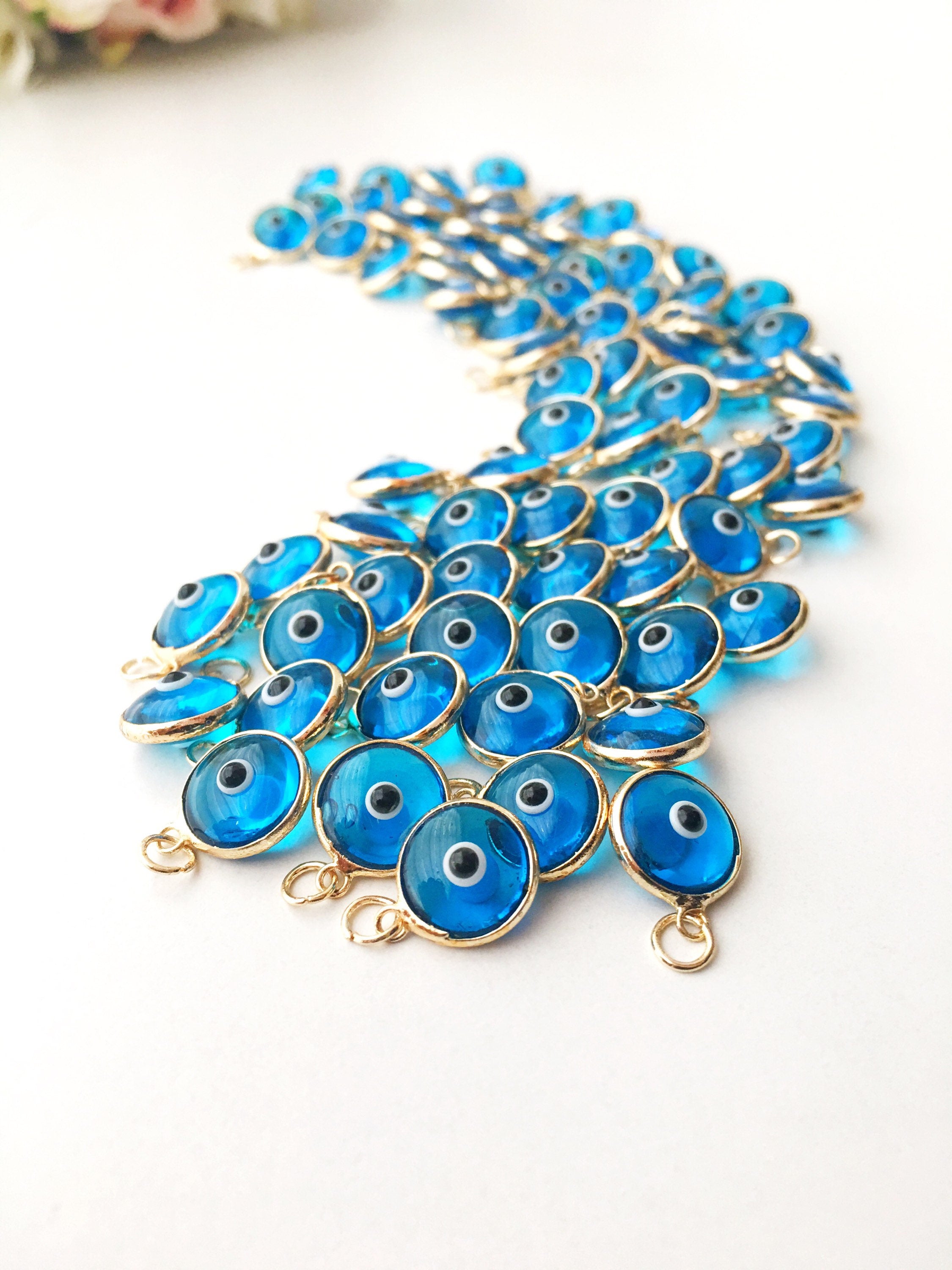 Turquoise evil eye charm featuring a vibrant blue color with a protective symbol, available in silver and gold finishes.