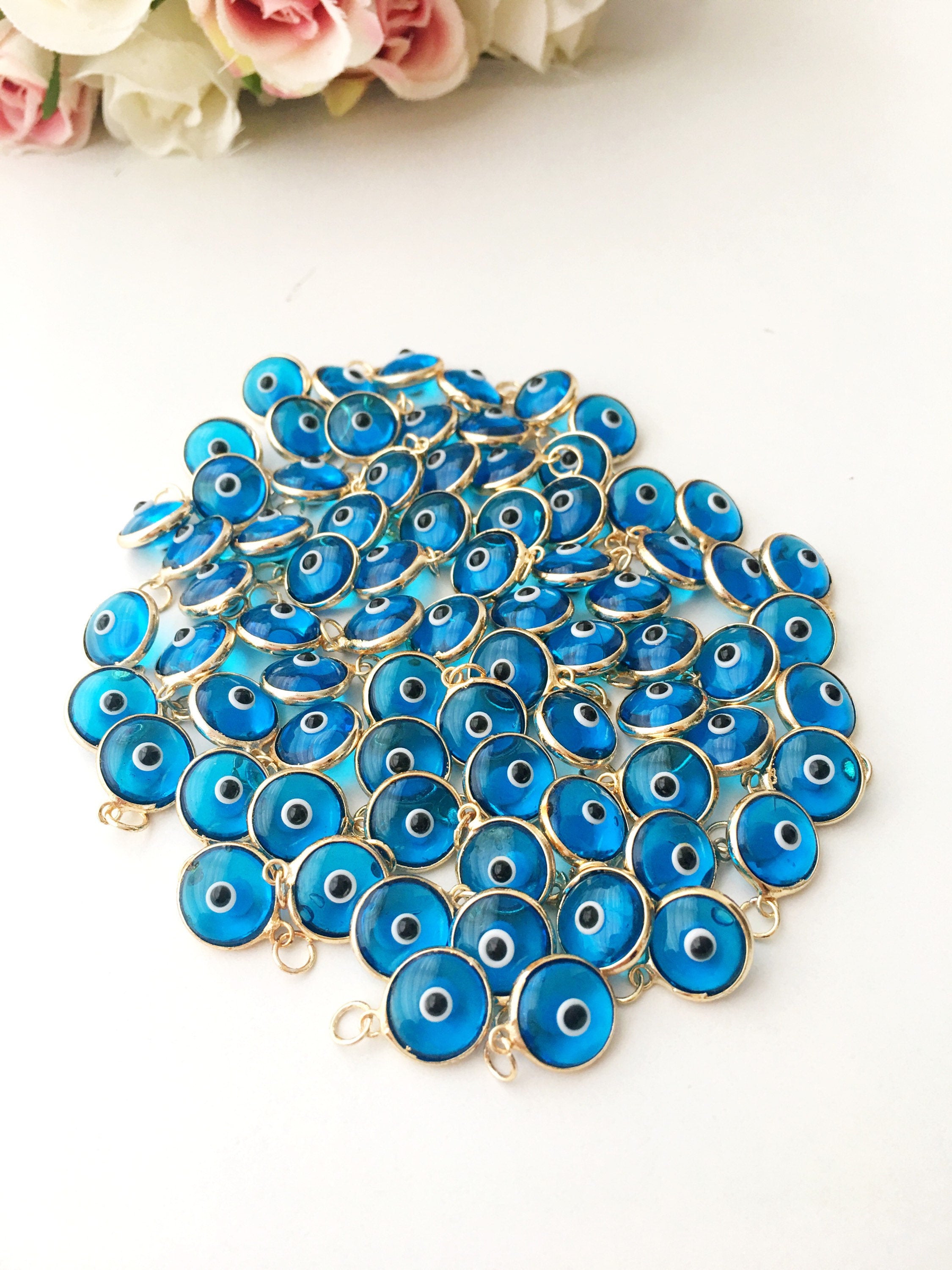 Turquoise evil eye charm featuring a vibrant blue color with a protective symbol, available in silver and gold finishes.