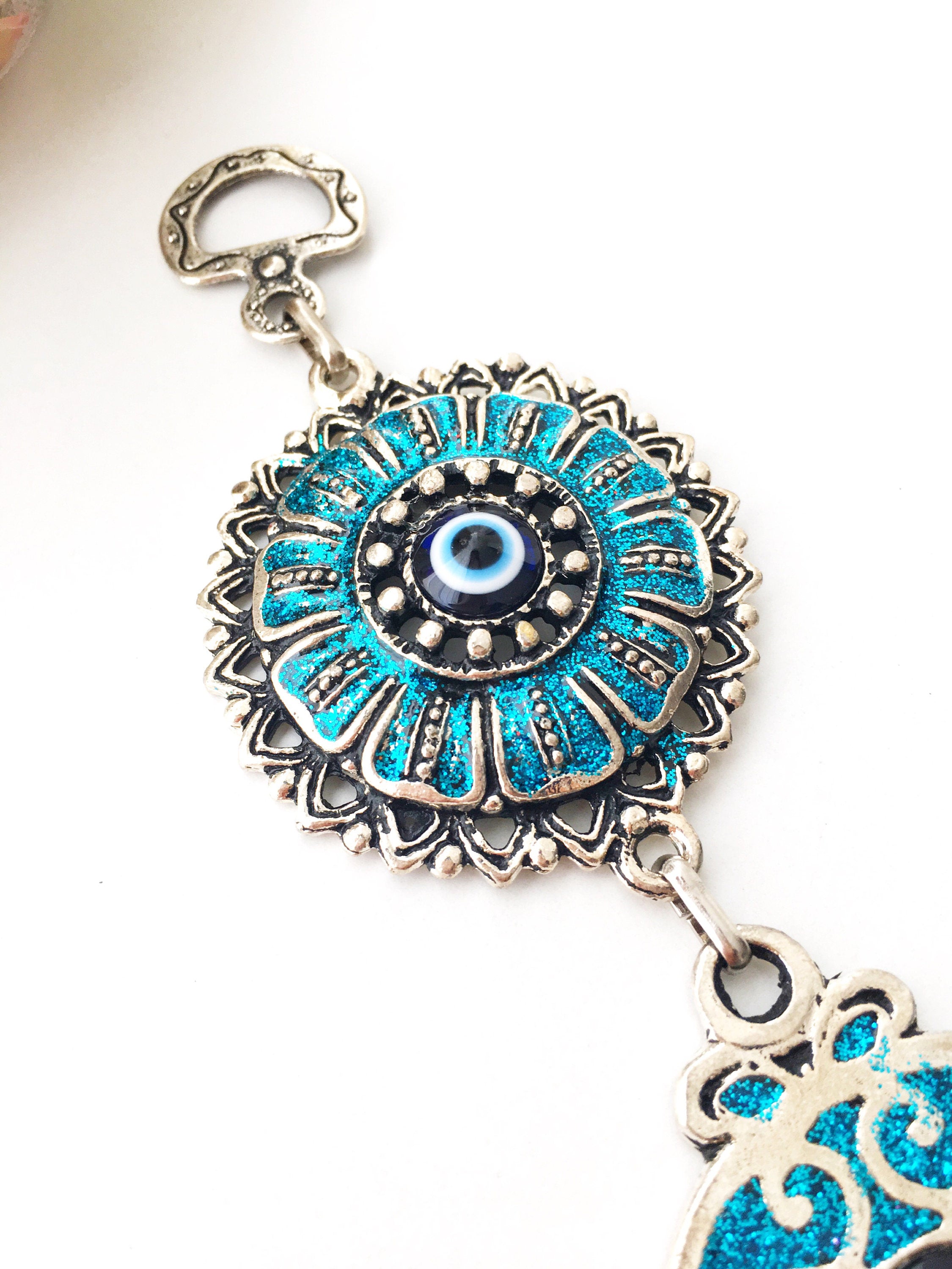 Turquoise Hamsa Evil Eye Wall Hanging featuring a mosaic metal hamsa hand and a large glass evil eye bead, symbolizing protection and good luck.